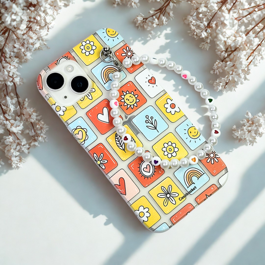 Phone case with colorful square designs on a light surface with flowers