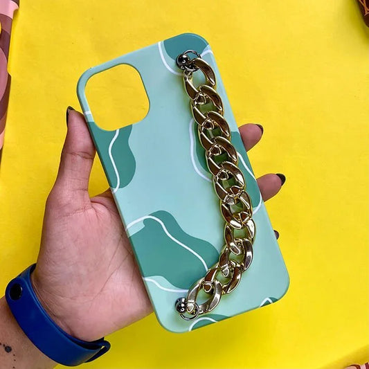 Green phone case with abstract pattern and gold chain charm, held in hand on yellow background