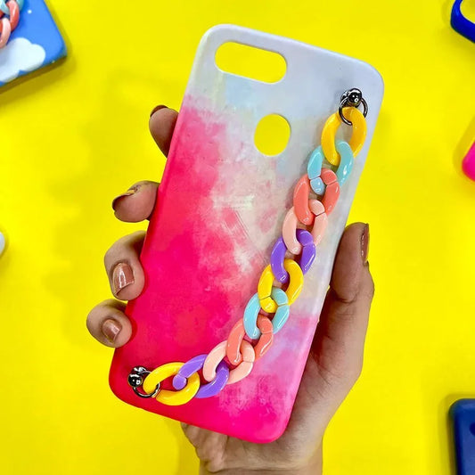 Hand holding a pink gradient phone case with a colorful chain charm, displayed on a yellow background.