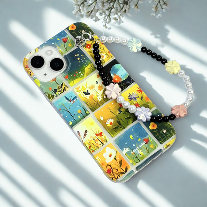 Phone case with nature-themed design and decorative strap on a light background