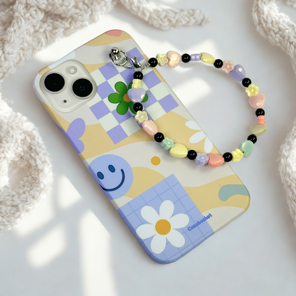 Phone case with colorful design and beaded strap on a light background
