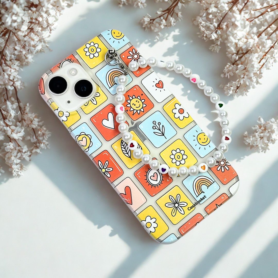 Phone case with colorful square designs on a light surface with flowers